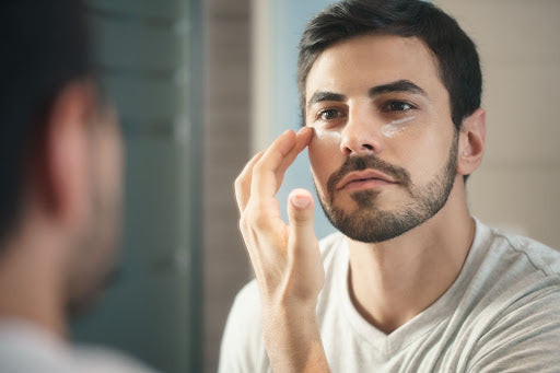 man applying eye cream