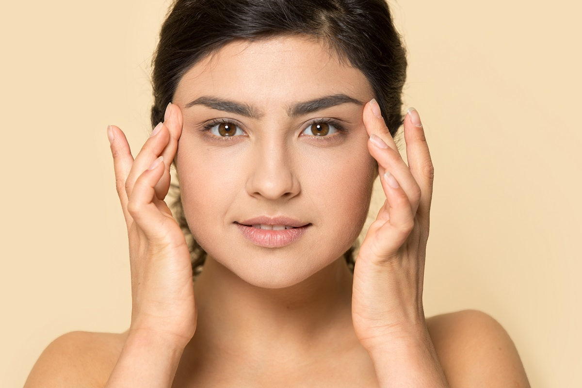 Headshot of indian millennial girl touch healthy skin